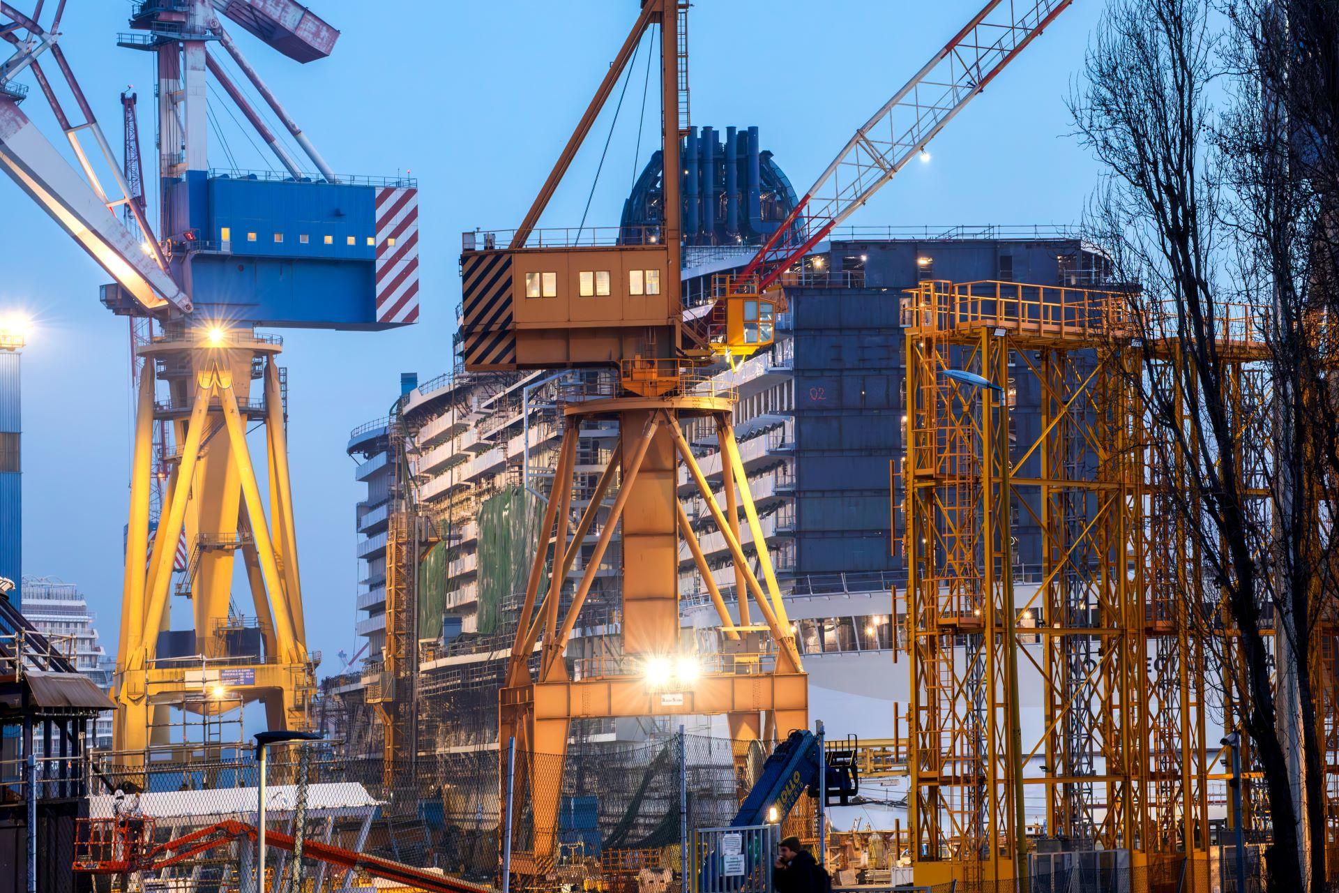 Industriekräne bei Nacht auf einer Baustelle