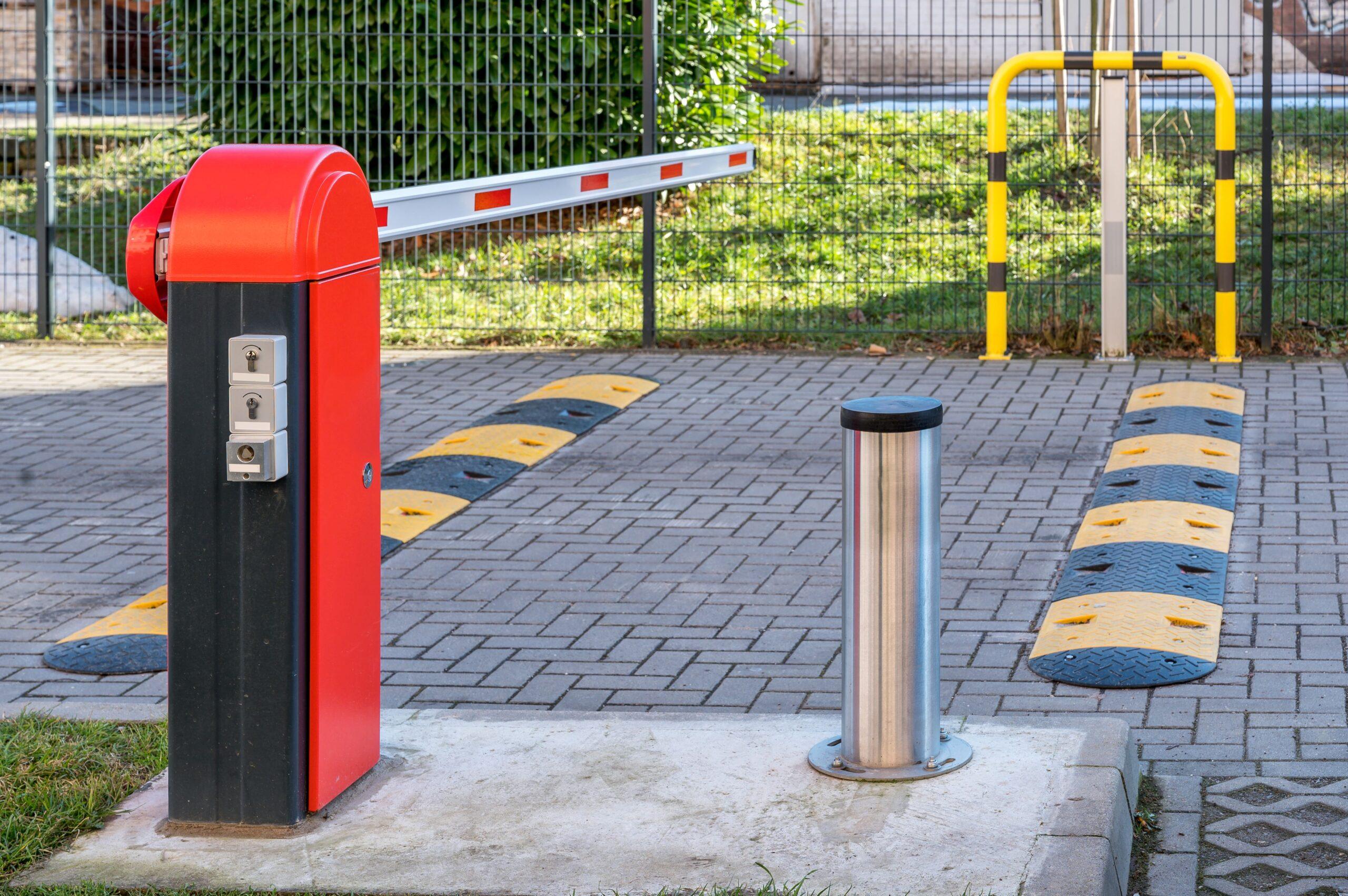 Elektrische Schranke und Temposchwellen am Eingang zu einem Parkplatz