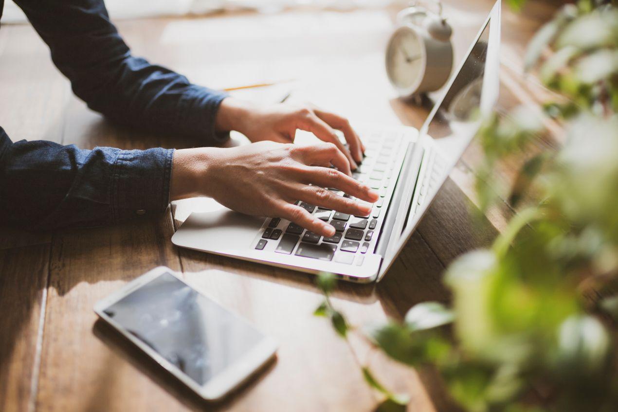 Eine Person tippt auf einem Laptop – Schritt-für-Schritt-Anleitung, um ein Auto online abzumelden und Zeit zu sparen.