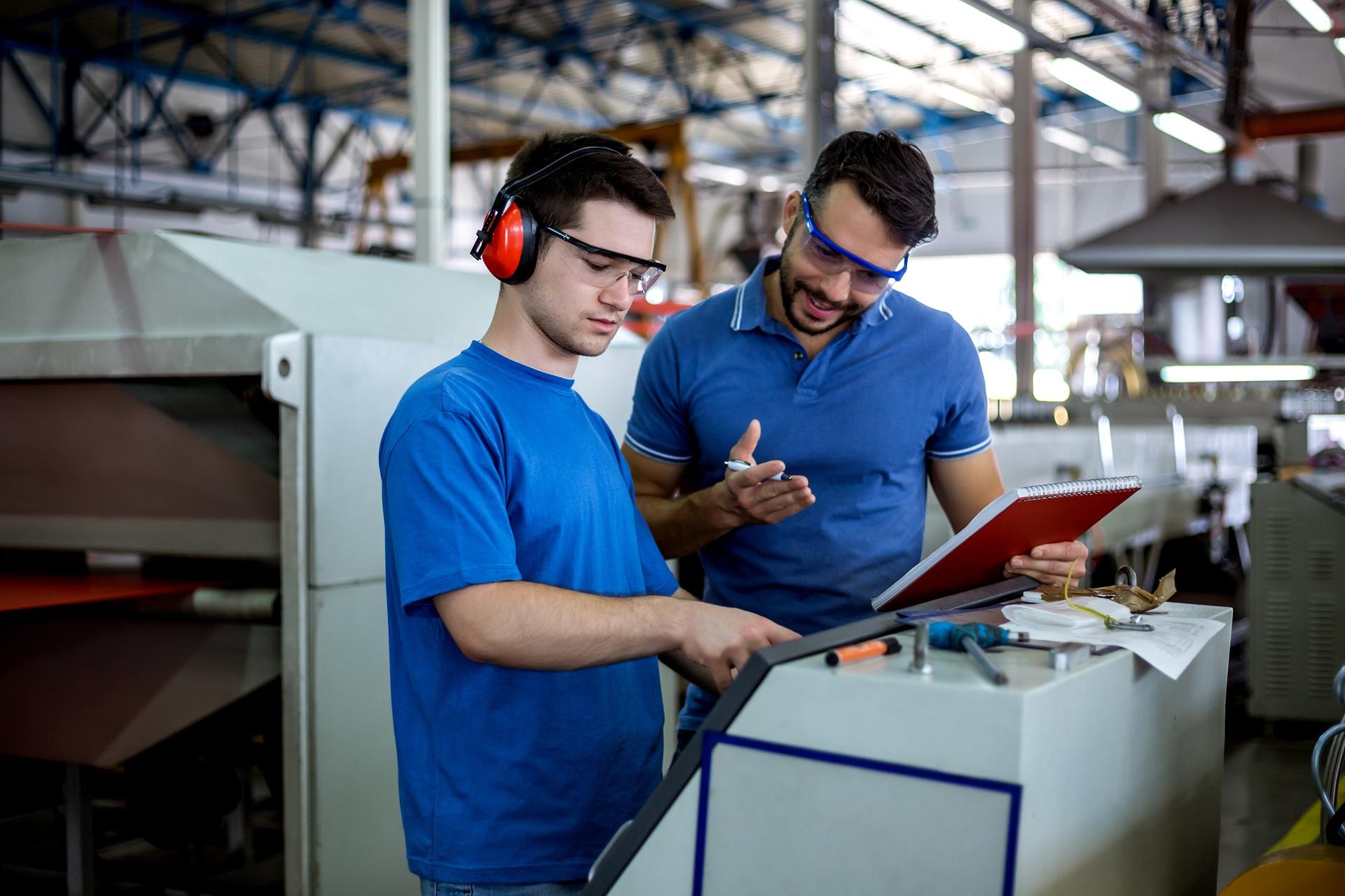 Zwei Mitarbeiter bei Qualitaetspruefung in Produktionshalle | Anwalt für Produkthaftung