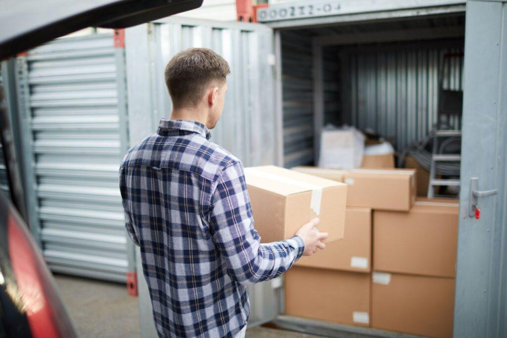 mann bringt paket in sicheren stauraum wie paketbox xxl