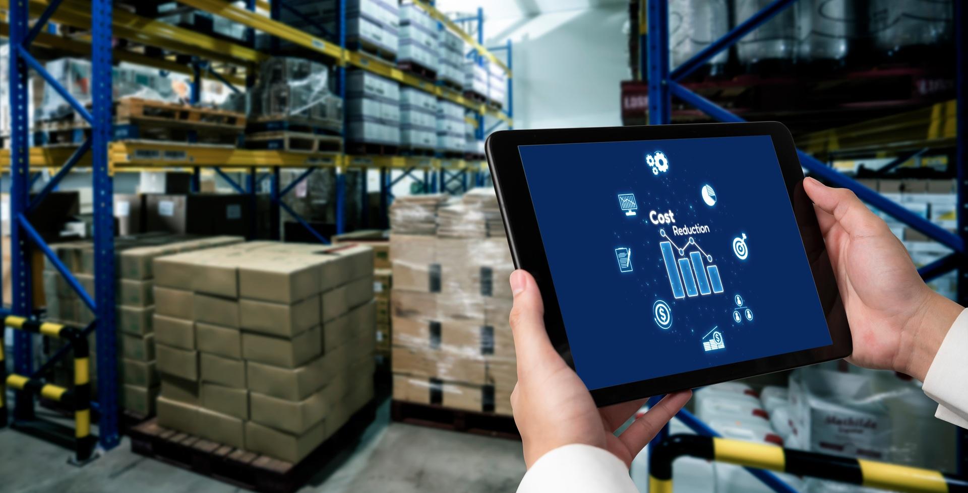 Tablet zeigt Kostendiagramme in Industrie-Lagerhalle | Photovoltaik Altenburg